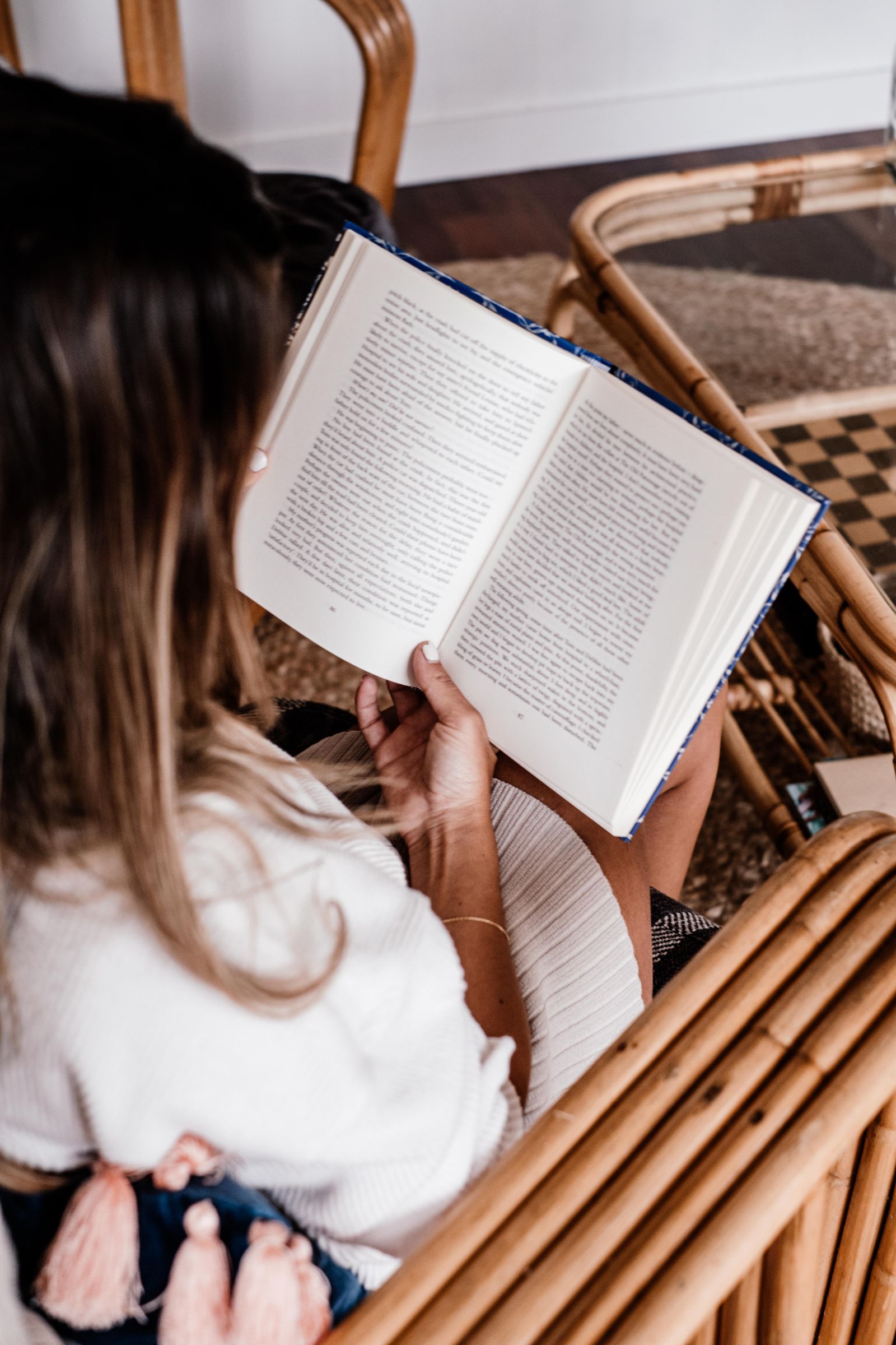 Woman enjoying a peaceful reading moment indoors with an open book