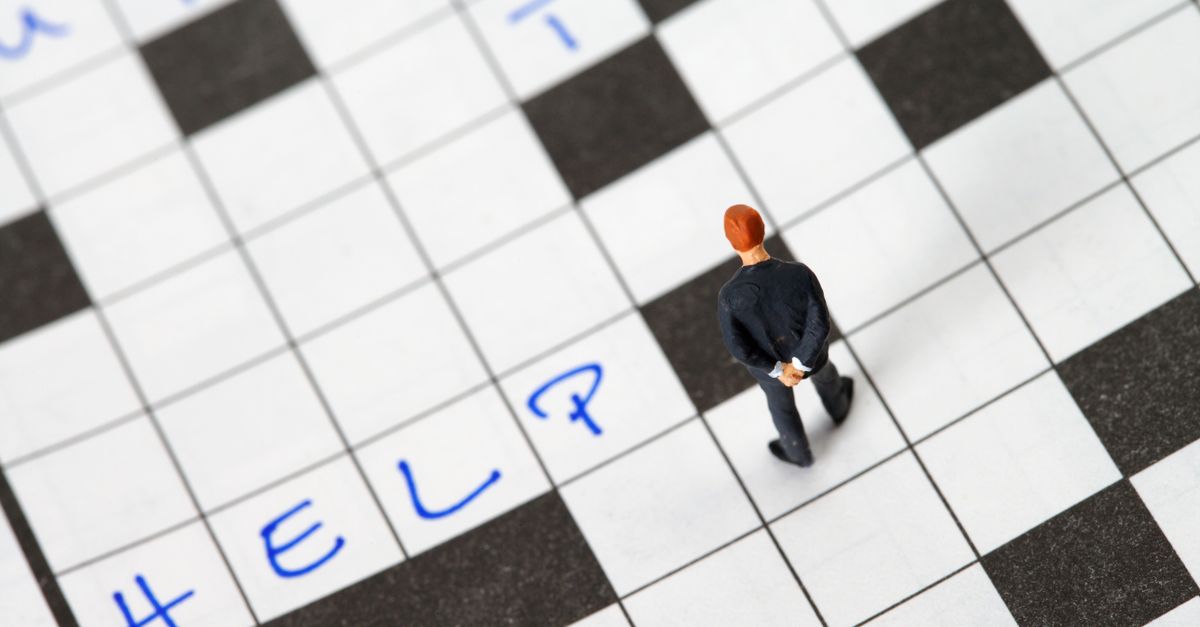 Close-up of a crossword puzzle grid being filled in