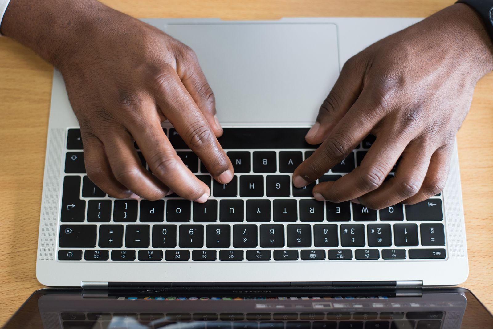 Hands typing on a laptop keyboard