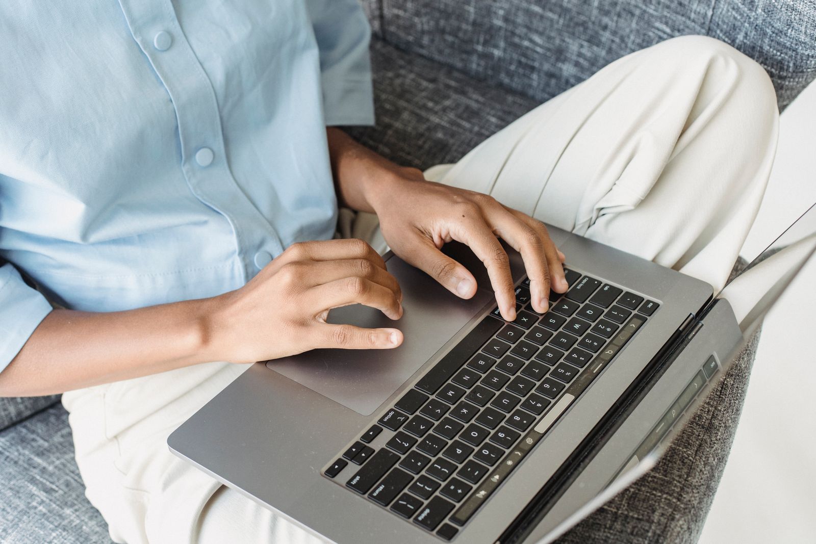 Hands typing on a laptop keyboard