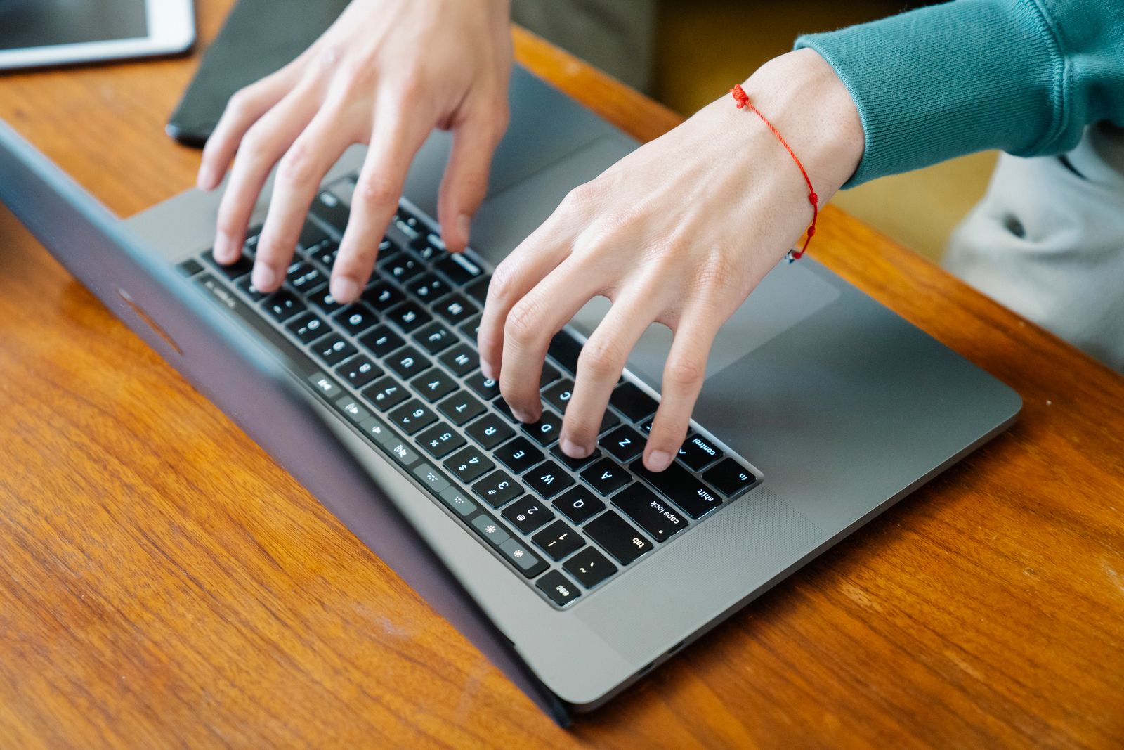 Hands typing on a laptop keyboard