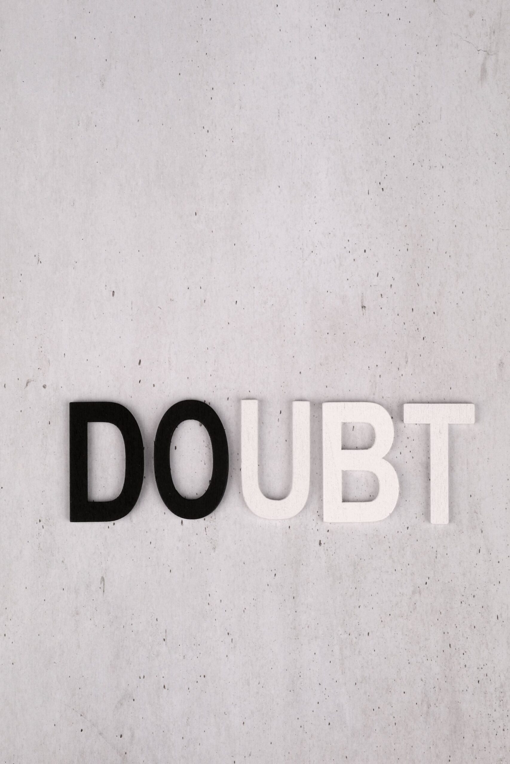 Black and white letter tiles spelling the word DOUBT