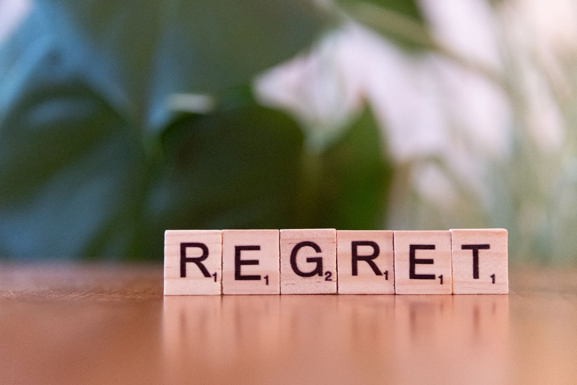 Close-up of wooden letter tiles spelling the word Regret