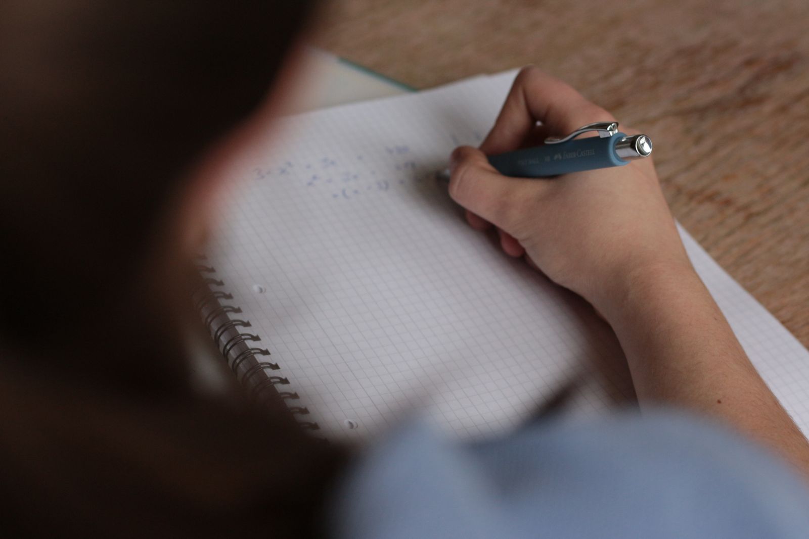 Close-up of hands writing on paper
