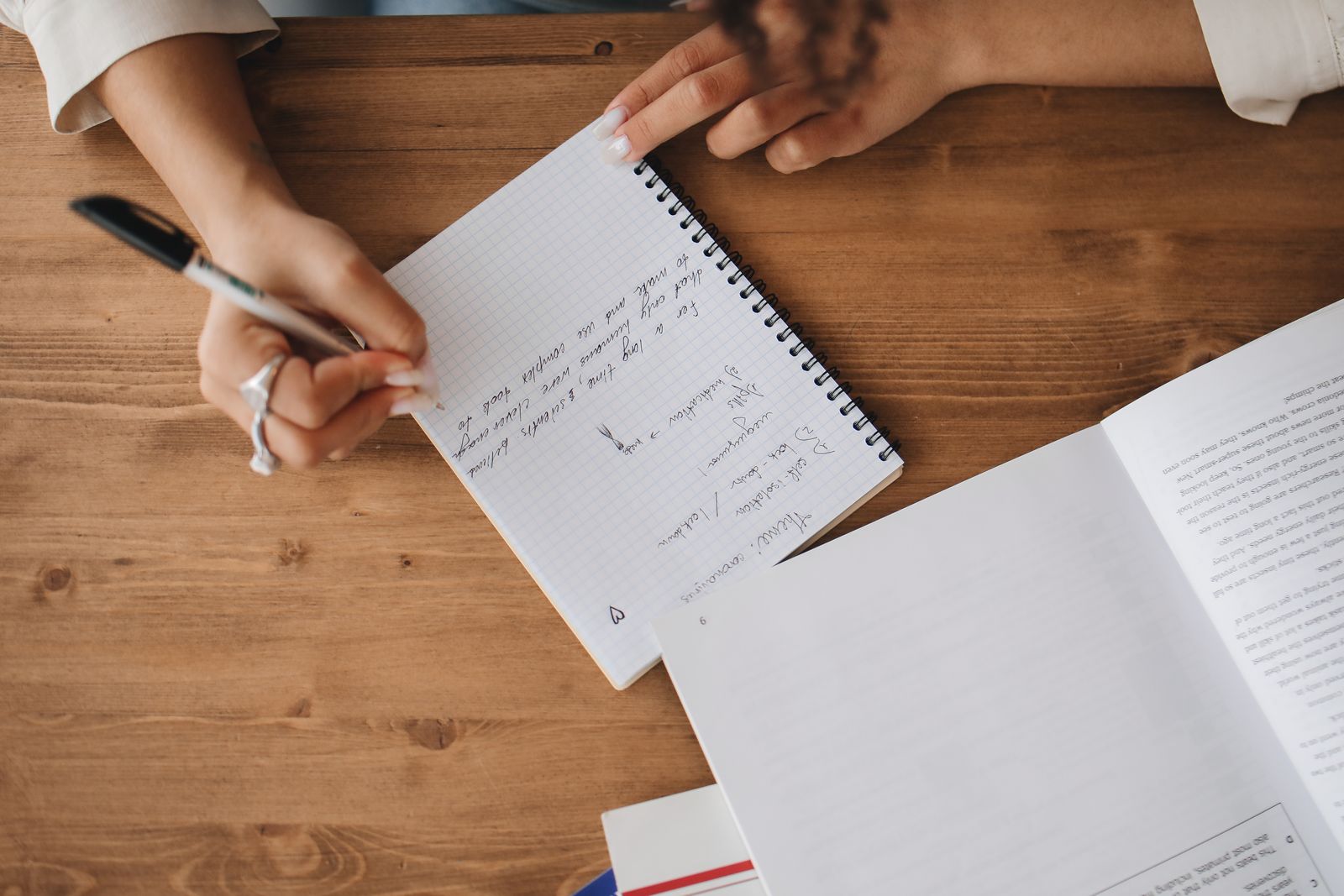 Top view of a person writing notes in a notebook