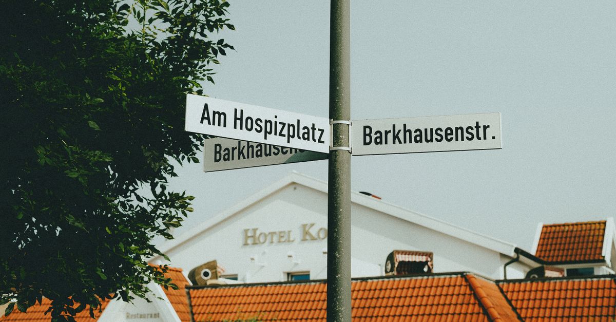 German street sign with a street name and building name