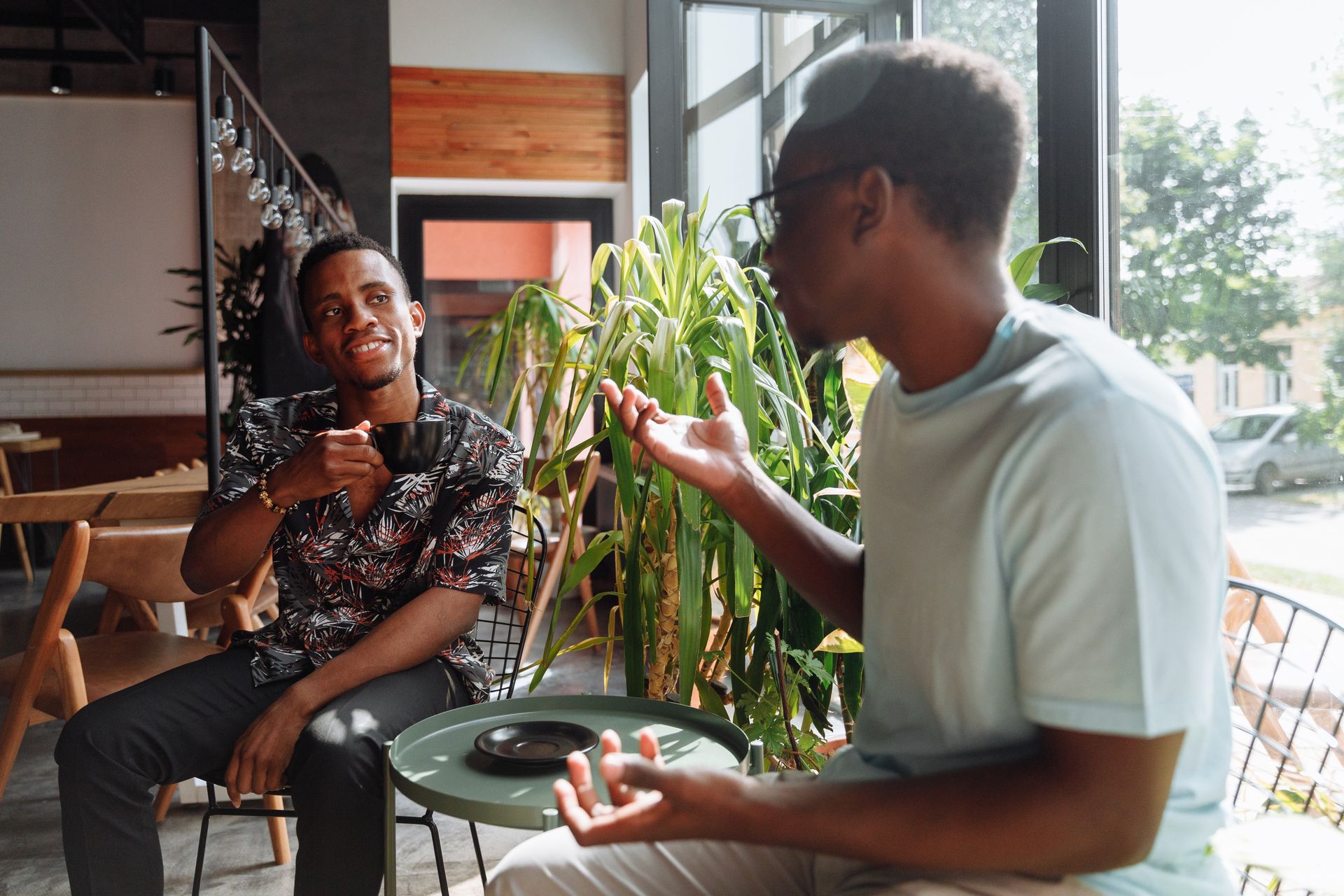 Two friends having a lively conversation in a cozy coffee shop