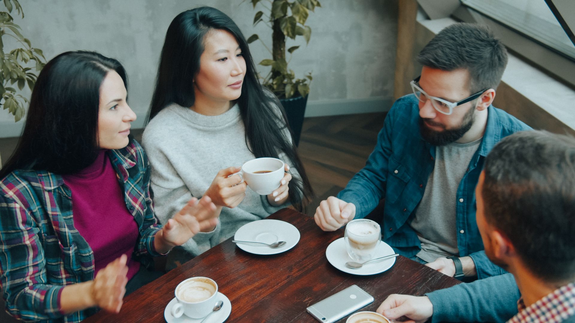Group of friends enjoying coffee and conversation indoors