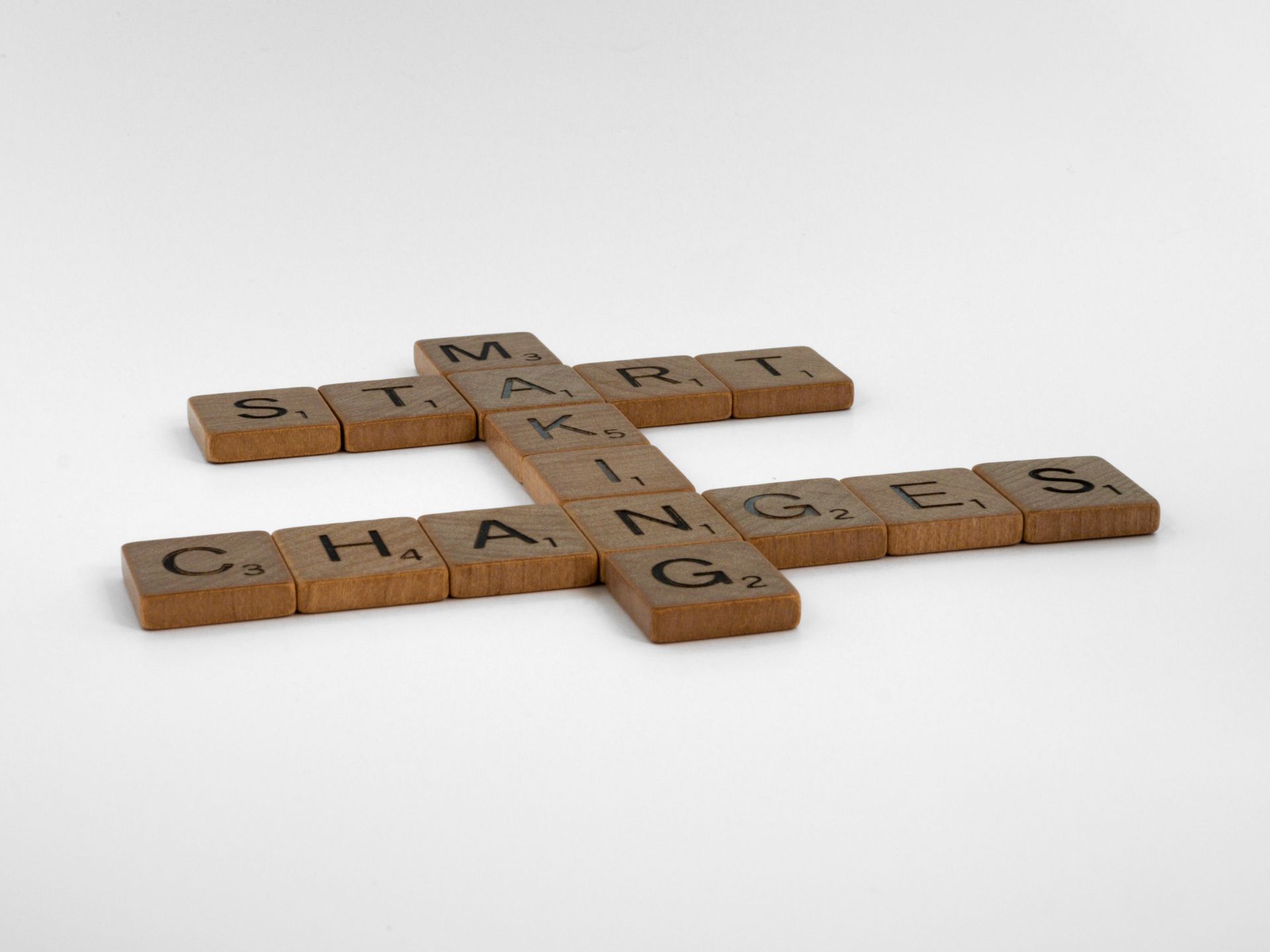 Wooden Scrabble tiles arranged on white background