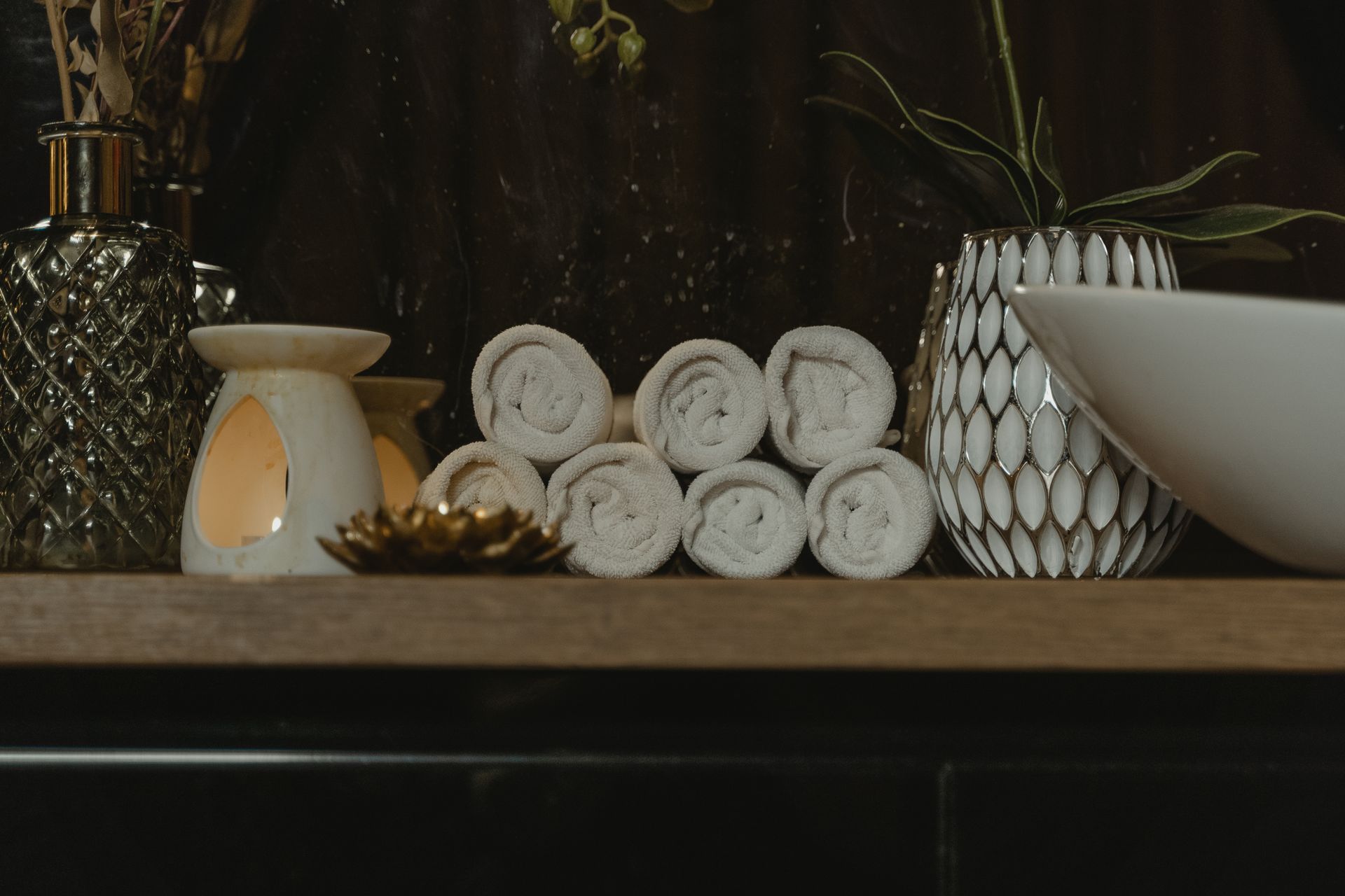 Serene spa setting with rolled towels and candlelight