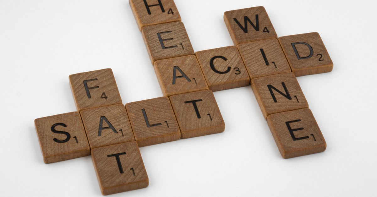 Wooden letter tiles arranged as a crossword on a white surface