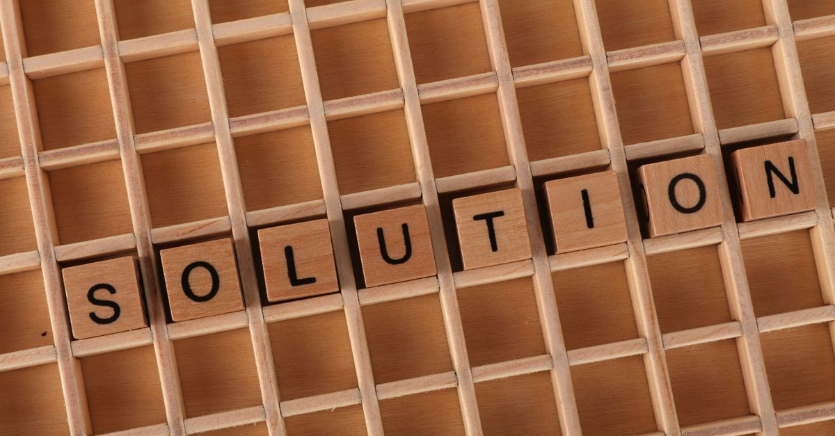 Wooden word tiles spelling a solution on a crossword grid