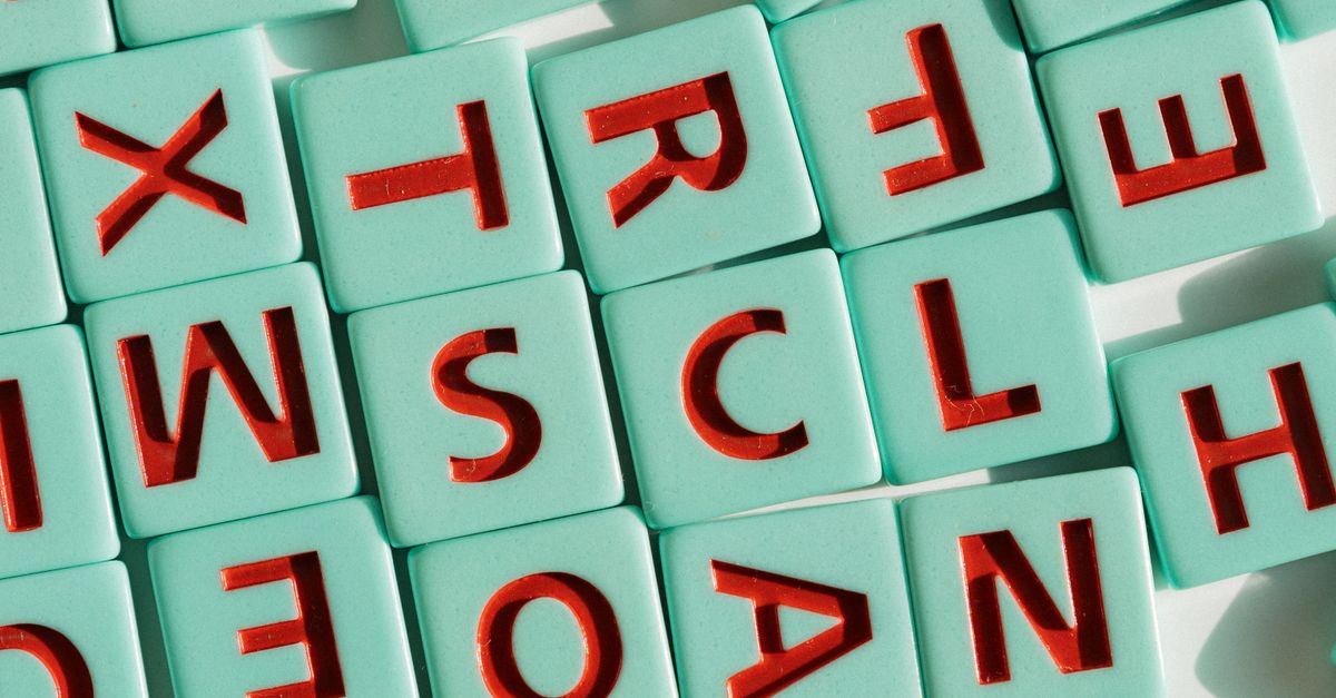 Colorful Scrabble tiles arranged in light