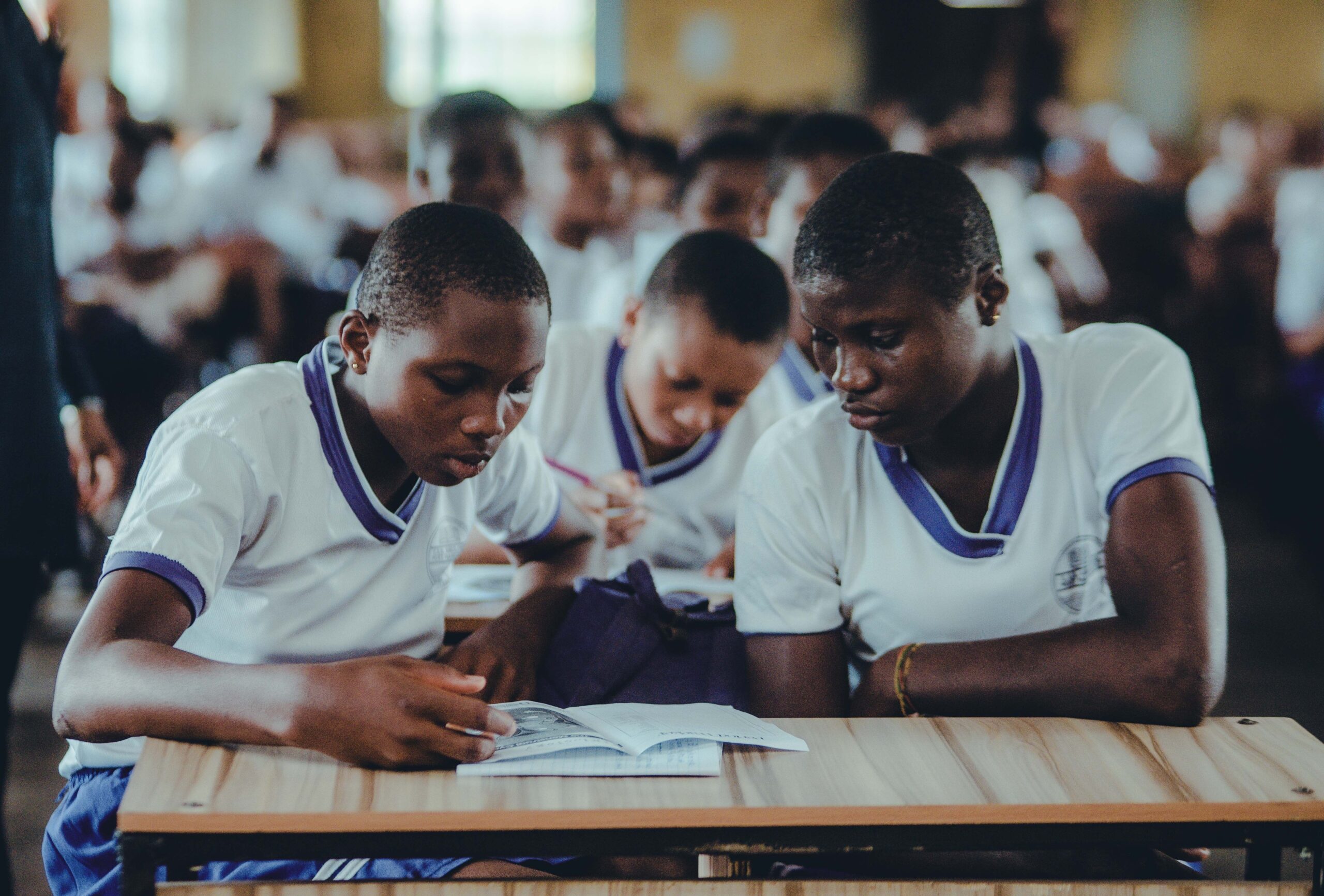 African students concentrating on their studies in a classroom setting, wearing uniforms.