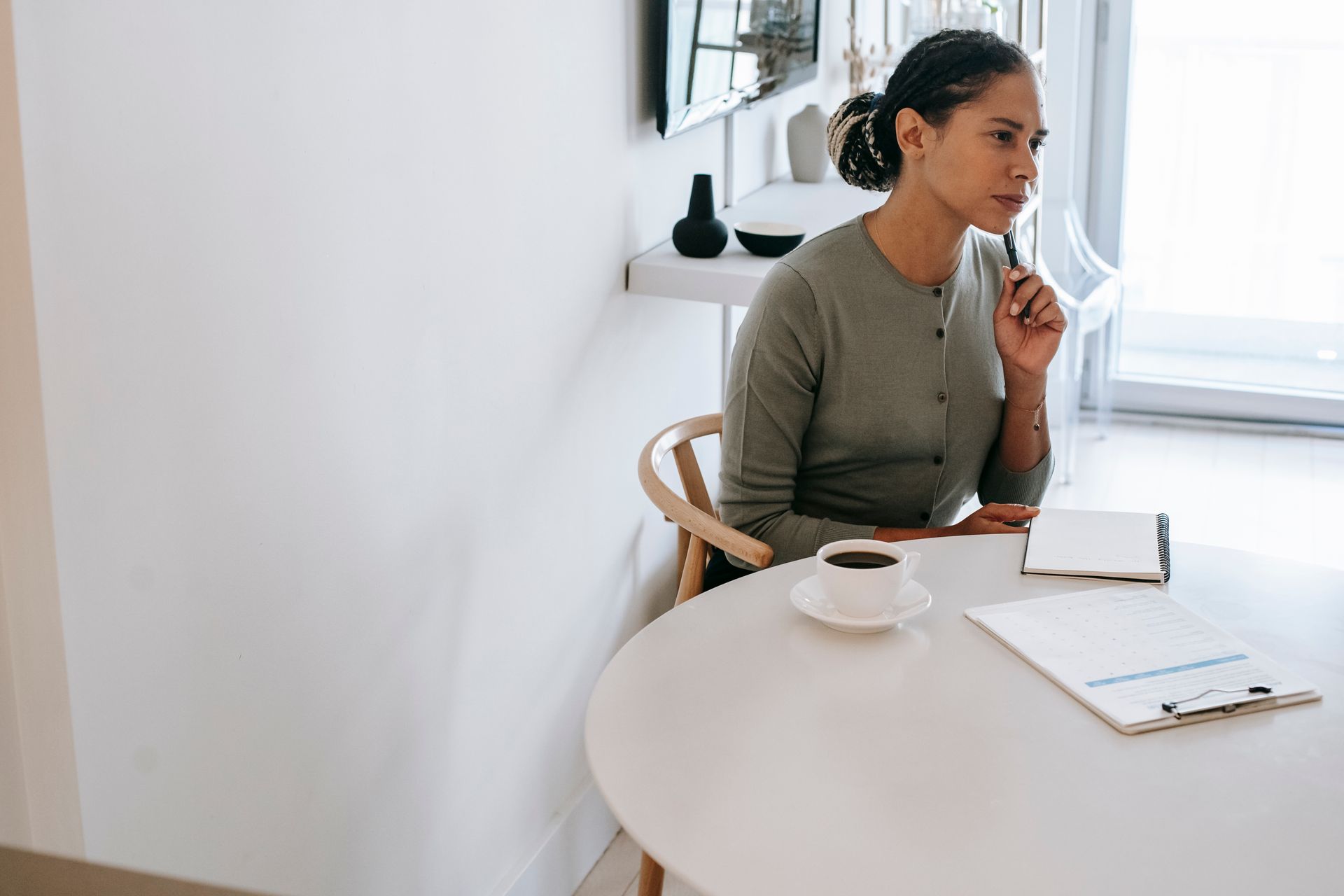 Woman thinking with a notebook and coffee