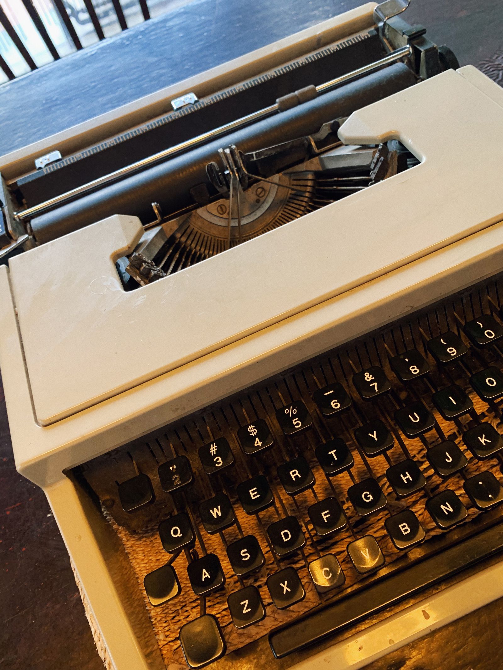 Close-up of a vintage typewriter on a wooden table in a cozy setting
