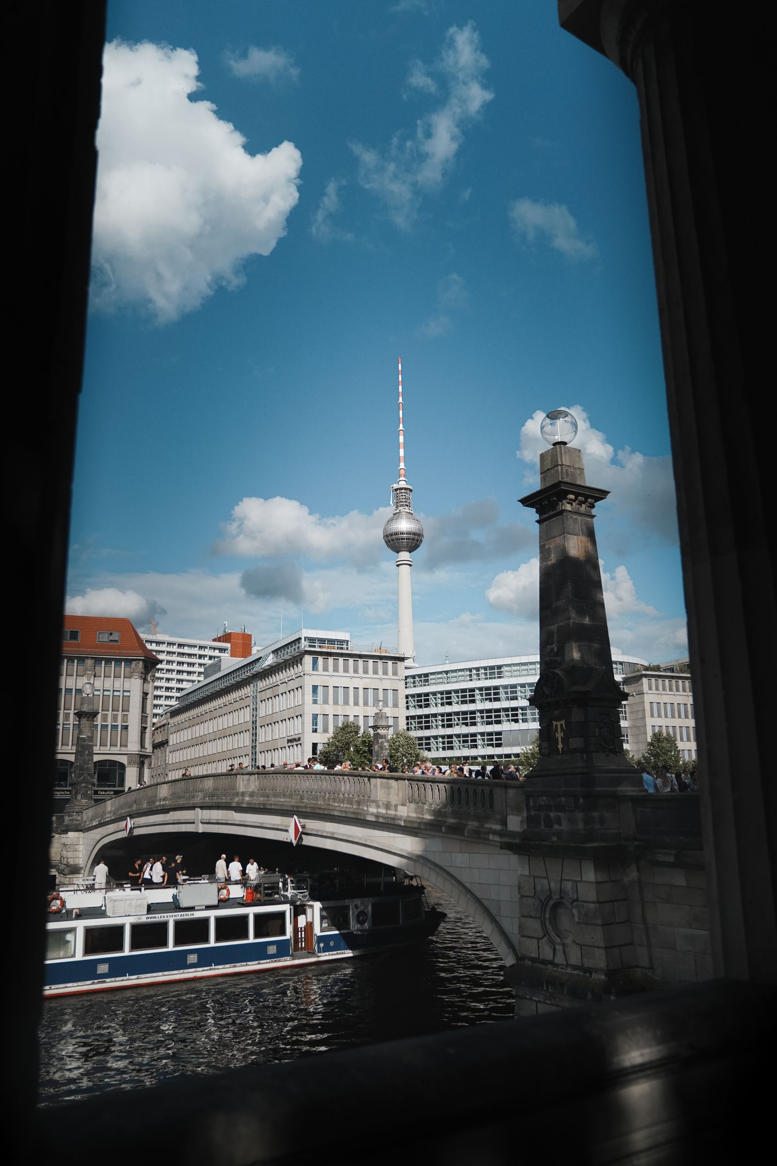 A striking view of Berlin's TV Tower framed by an arch bridge and river