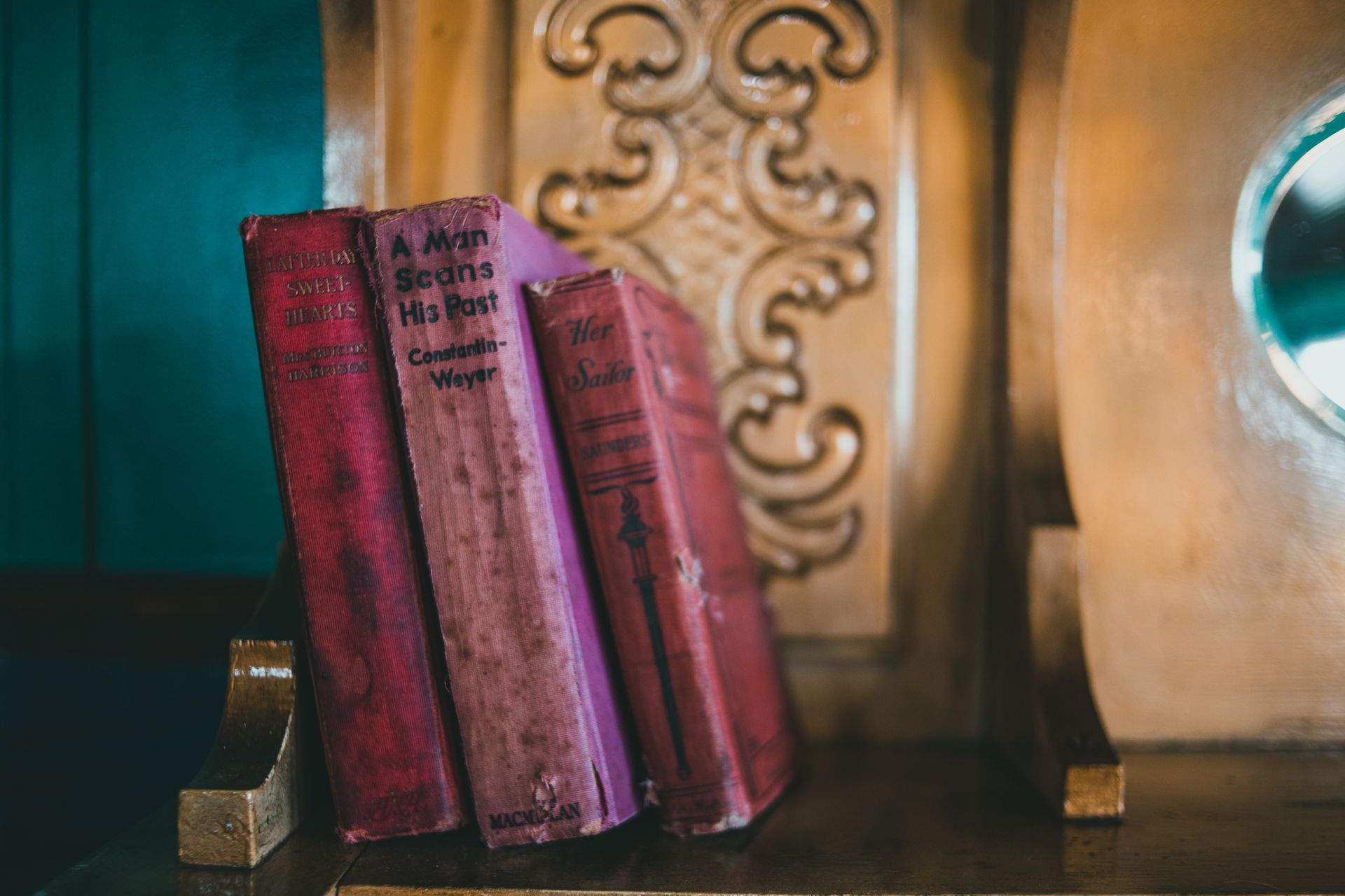 Antique books on a decorative wooden shelf