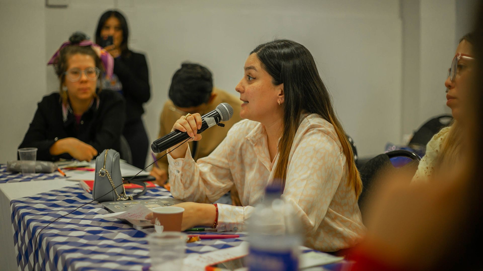 Woman holding a microphone during a group discussion